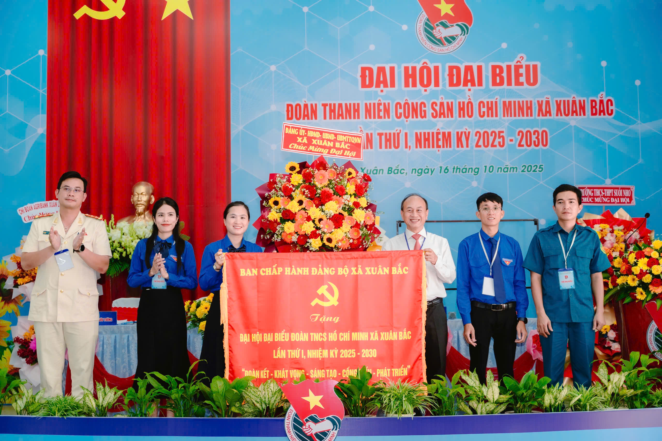 Ông Trần Lâm Sinh - Bí thư Đảng ủy, Chủ tịch HĐND xã tặng hoa và bức trướng chúc mừng Đại hội