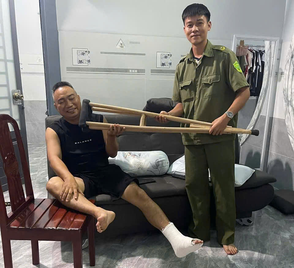 'Description: A person holding crutches and sitting next to a person in a room

AI-generated content may be incorrect.'