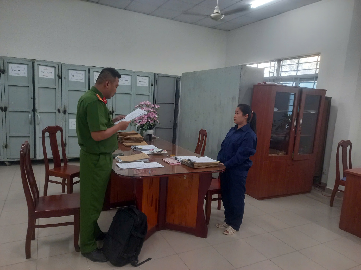 ''Description: A person in uniform standing at a desk with a person in front of her

AI-generated content may be incorrect.''