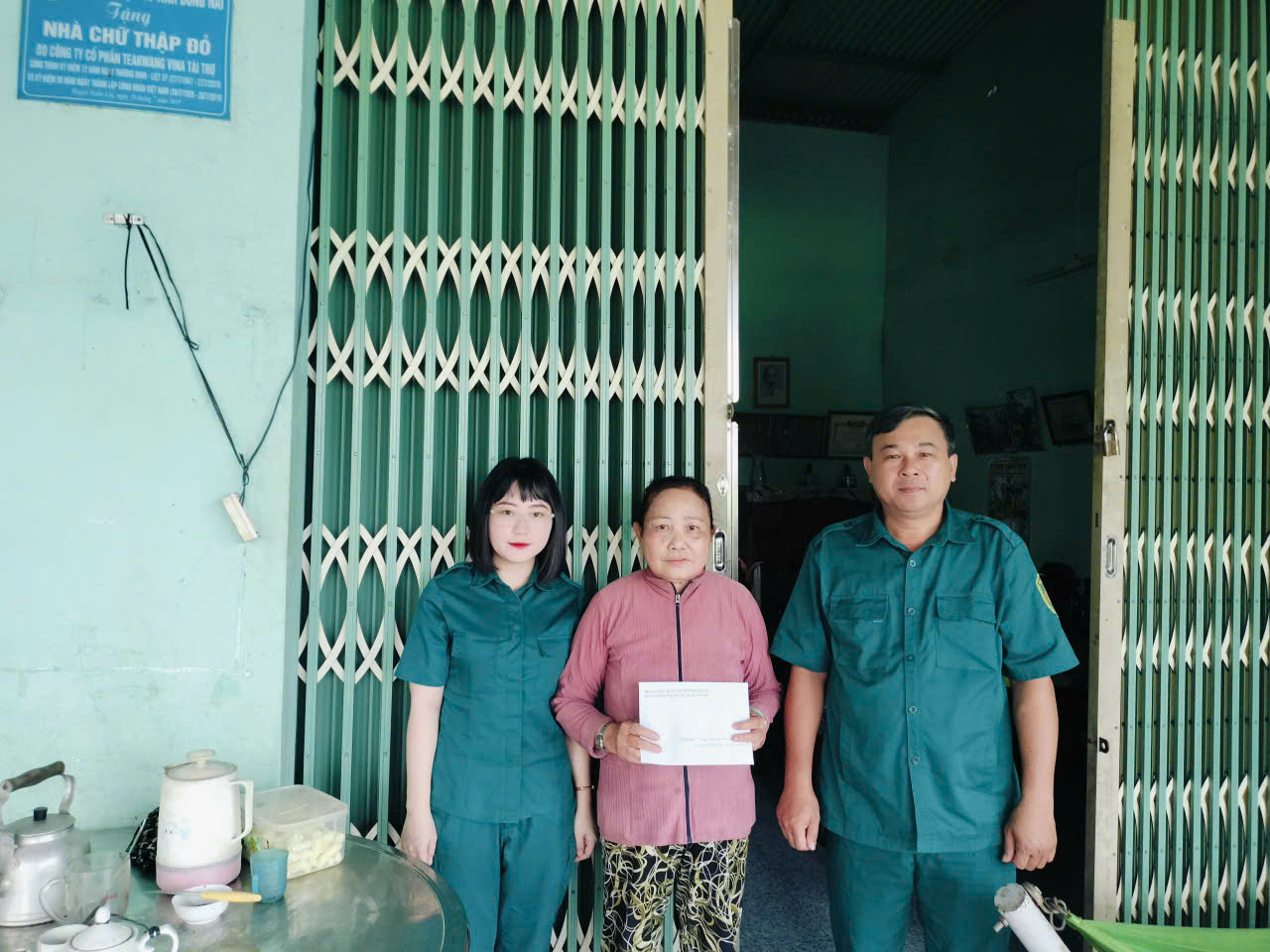 Đồng chí Phạm Văn Hải - Phó Bí thư chi bộ Quân sự xã trao tiền phụng dưỡng cho bà Giang Thị Lệ Thuỷ - con liệt sĩ